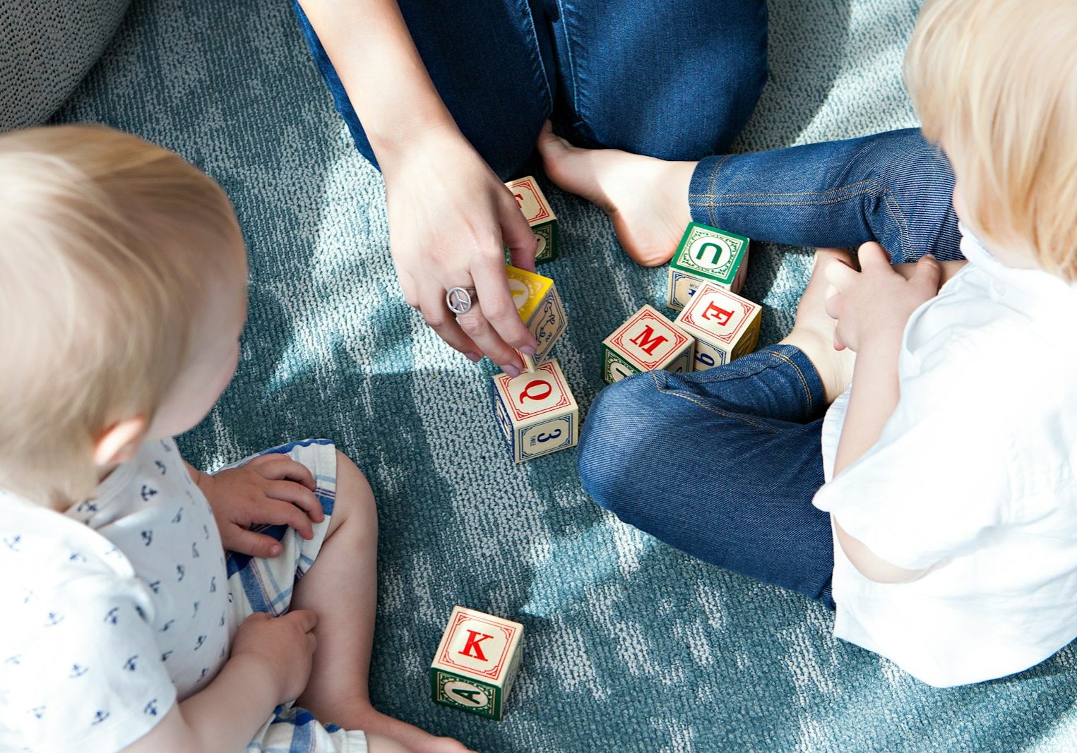 two toddler playing letter cubes